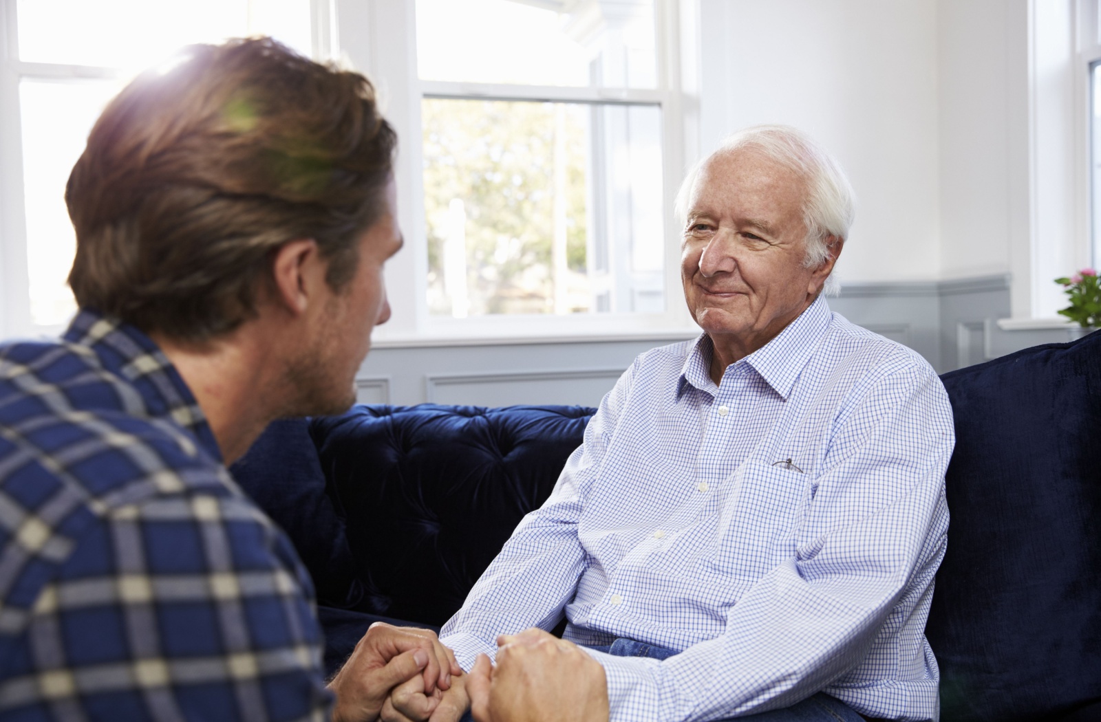 An adult and their senior parent have a thoughtful discussion about future senior care plans.