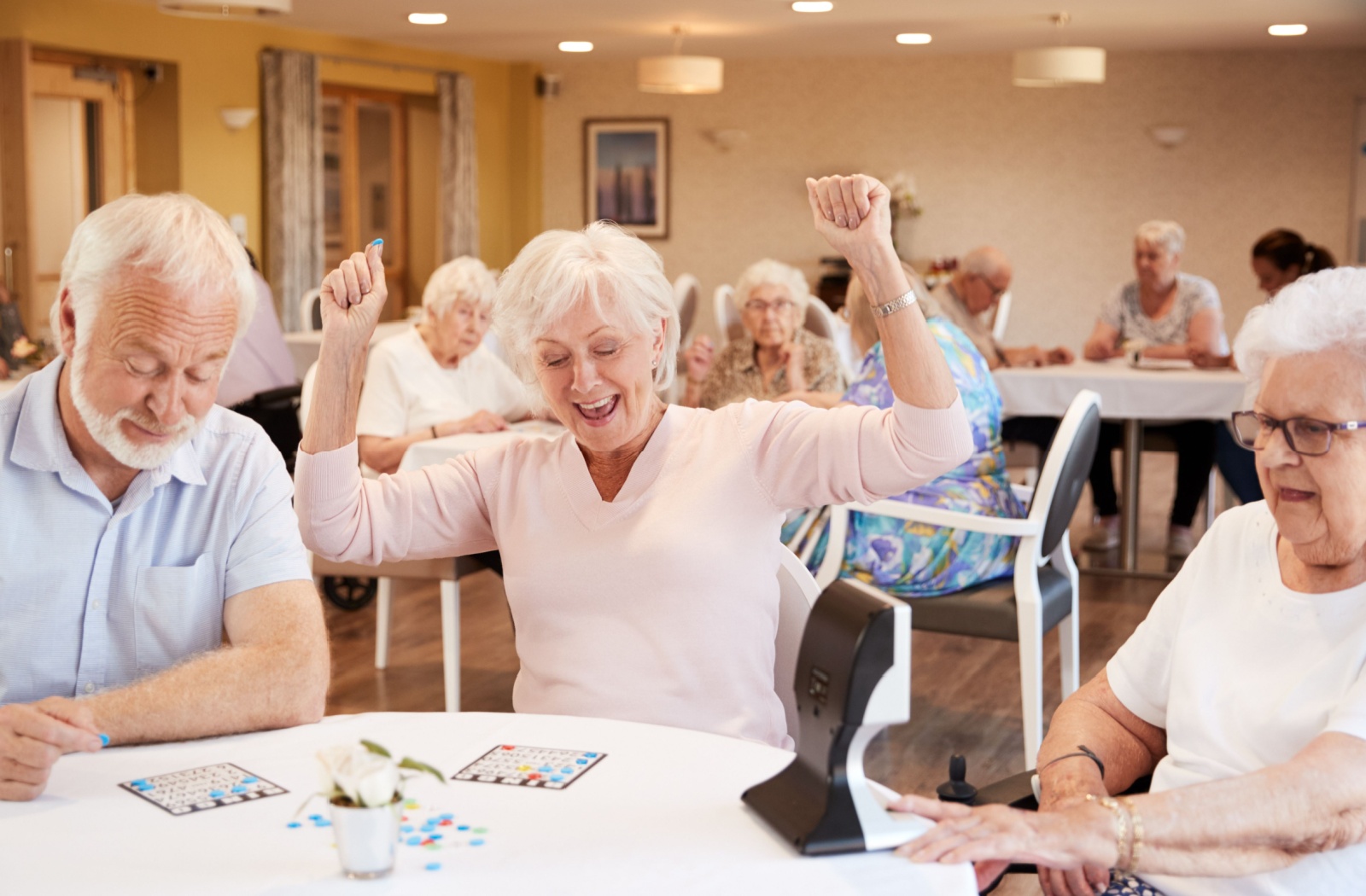 Senior residents at State Street Senior Living having a blast playing Bingo. One lucky resident celebrates her win.